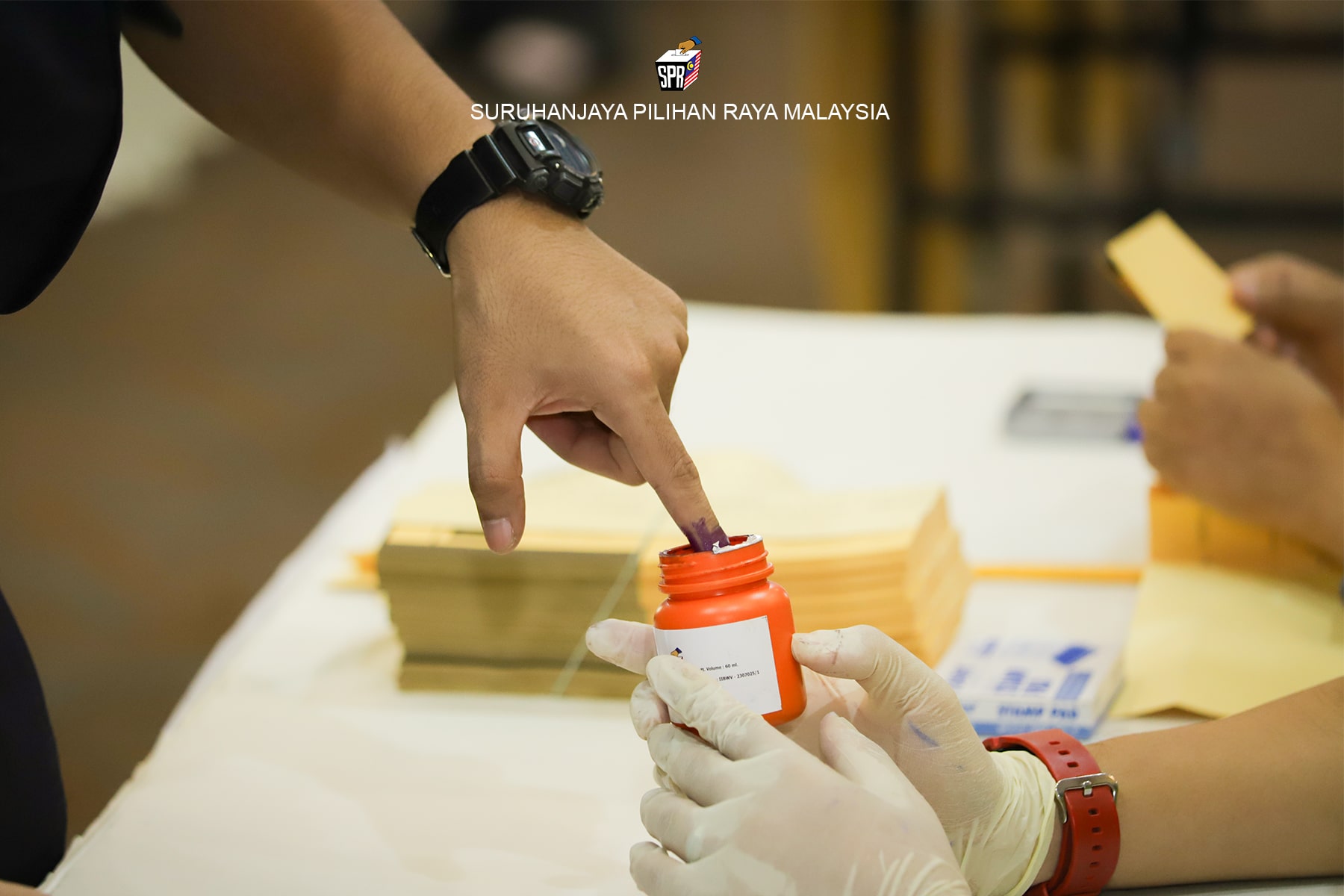 A voter dipping a finger in an indelible ink. Photo by Mlaysia's Election Commission