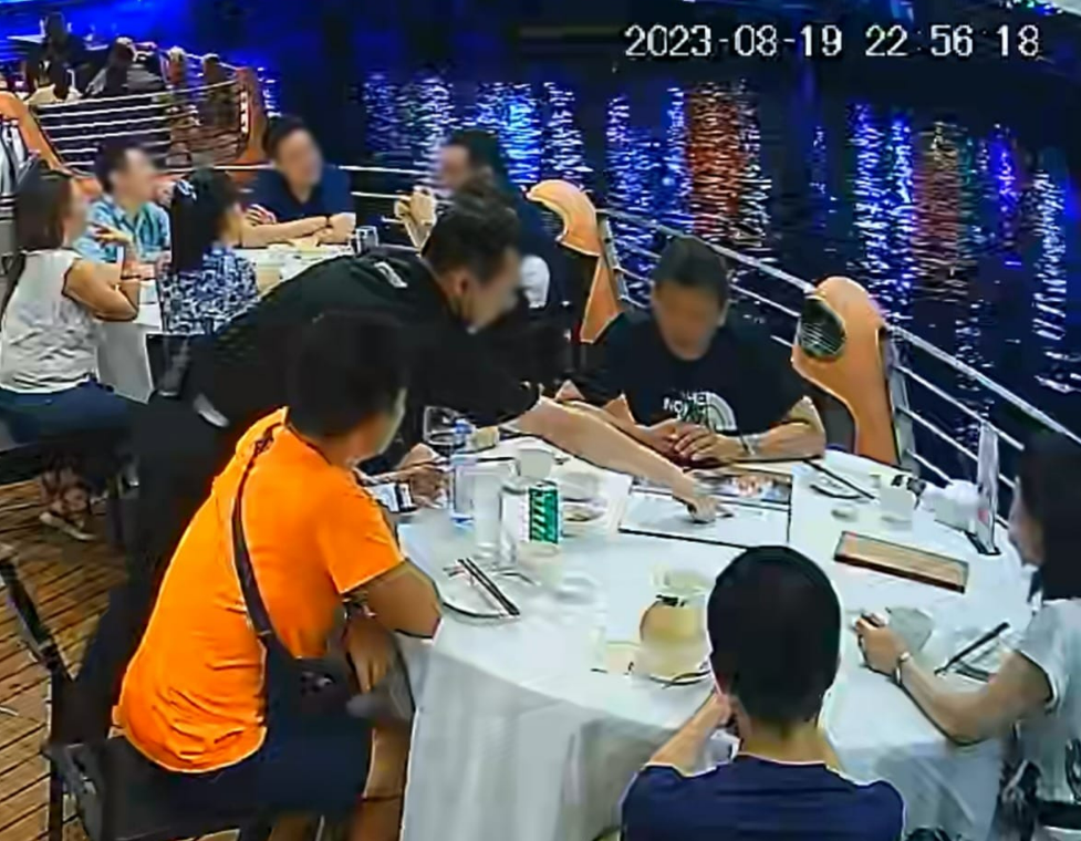 Restaurant staff seen pointing at the menu to communicate the price of Alaskan crab. (Photo: Paradise Group/ Facebook)