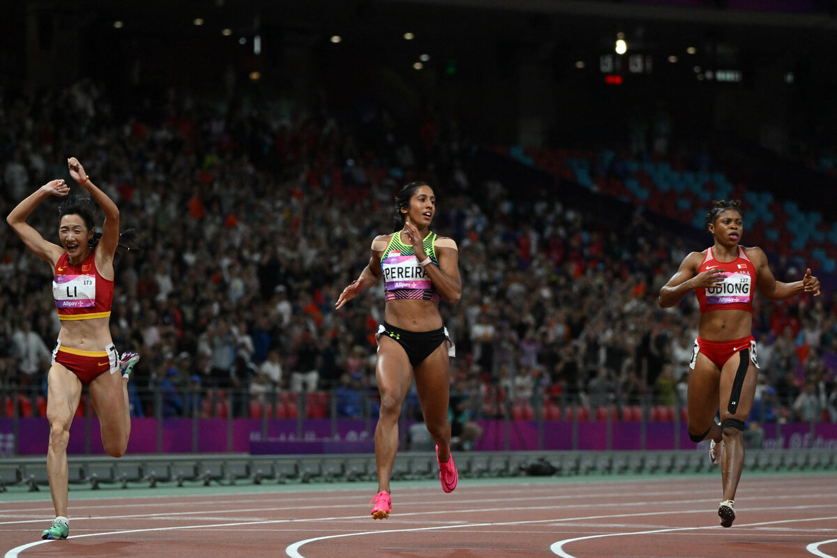 Singapores Shanti Pereira (C) crosses the finish line to win the women's 200m final athletics event during the 2022 Asian Games in Hangzhou in China's eastern Zhejiang province on October 2, 2023. (Photo by HECTOR RETAMAL / AFP)
