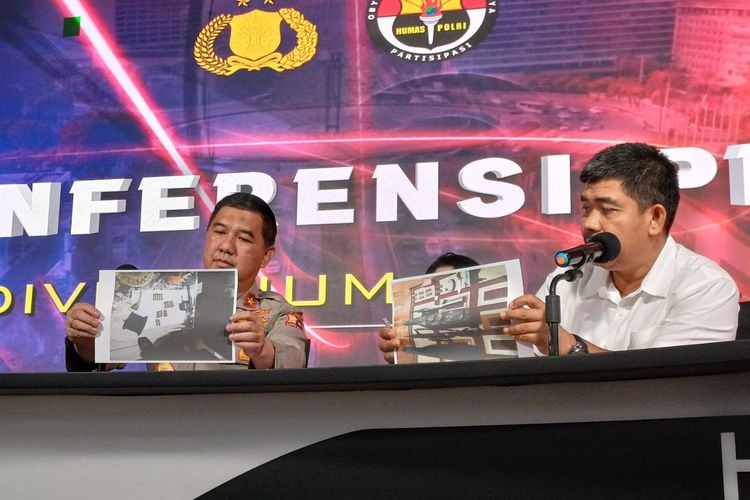 The Head of the Public Relations Bureau of the Indonesian National Police Division of Public Relations, Brigadier General Ahmad Ramadhan, and the Spokesperson for Densus 88, Commissioner Aswin Siregar, holding a photo of several firearms seized during the arrest of 59 terrorism suspects in October 2023, at a press conference at the National Police Headquarters, Jakarta, on Tuesday (31 Oct). (Photo: KOMPAS.com)