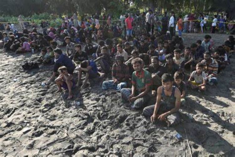 Rohingya Muslims take a break on the shore upon arriving at Blang Raya in Pidie, Aceh province, Indonesia, on Sunday (10 Dec). (Photo Reuters)
